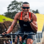 atleta numa bicicleta fazendo saudação para a câmera