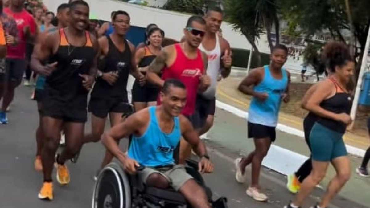 atleta de cadeira de rodas cercado por corredores