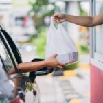pessoa pegando lanche em drive thru
